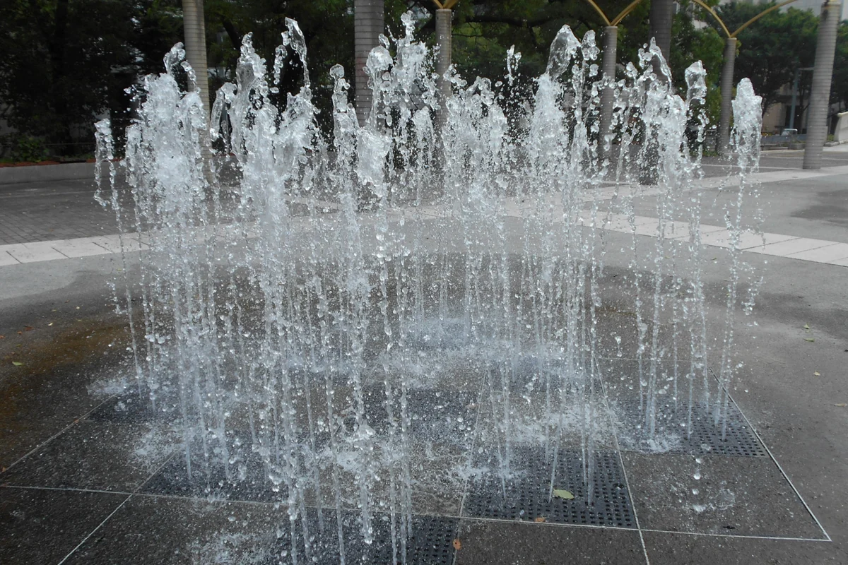 公園の地面から水が噴き出している噴水のイメージ写真