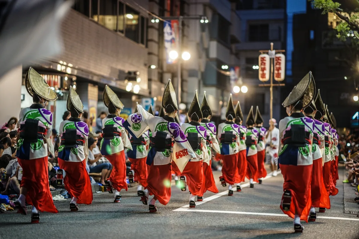夜の阿波踊りで踊る人々の後ろ姿