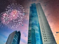 高層ビルのそばで夜空に花火が上がる都市夜景のイメージ