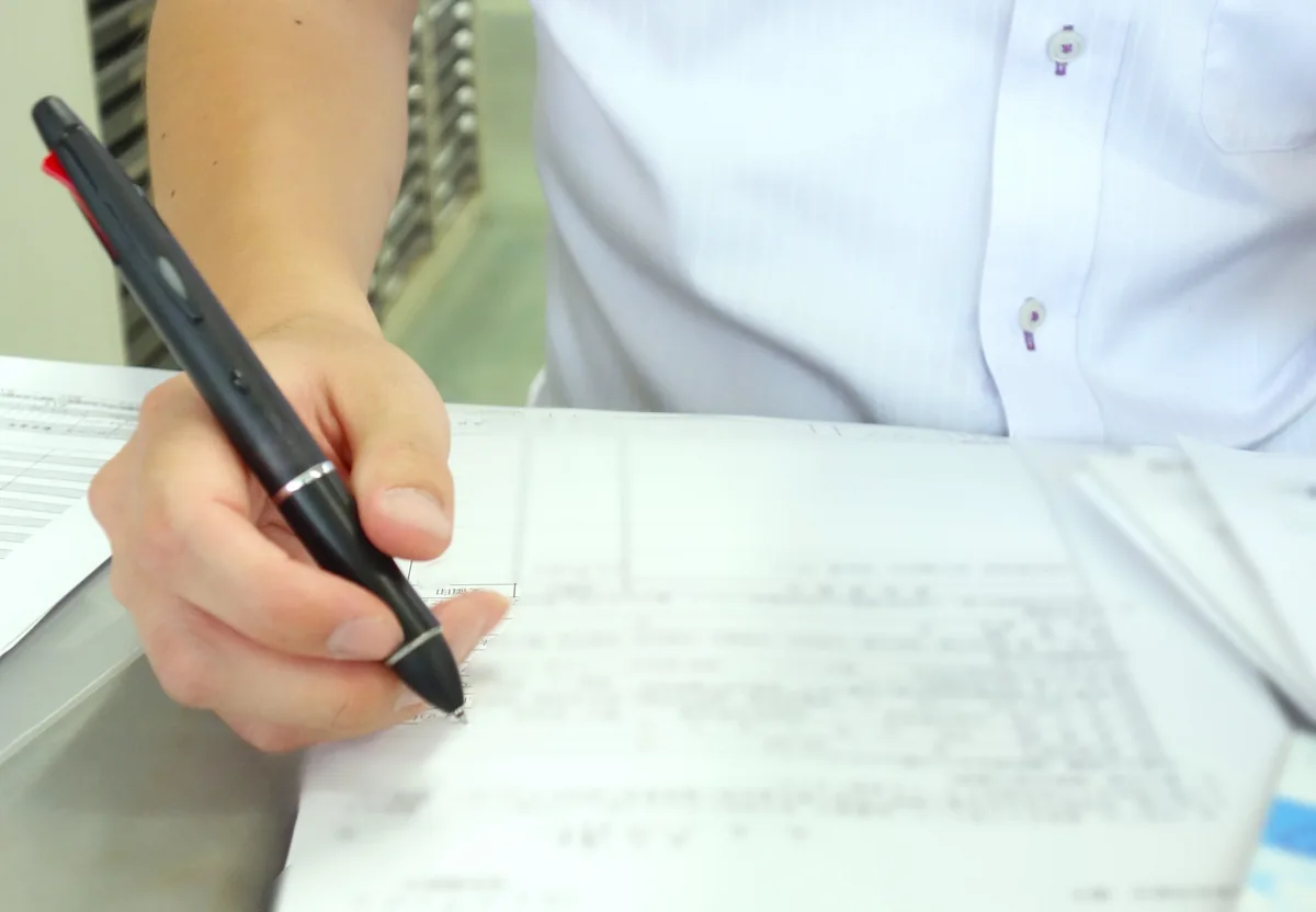 区役所で印鑑登録申請書に記入する人の手元