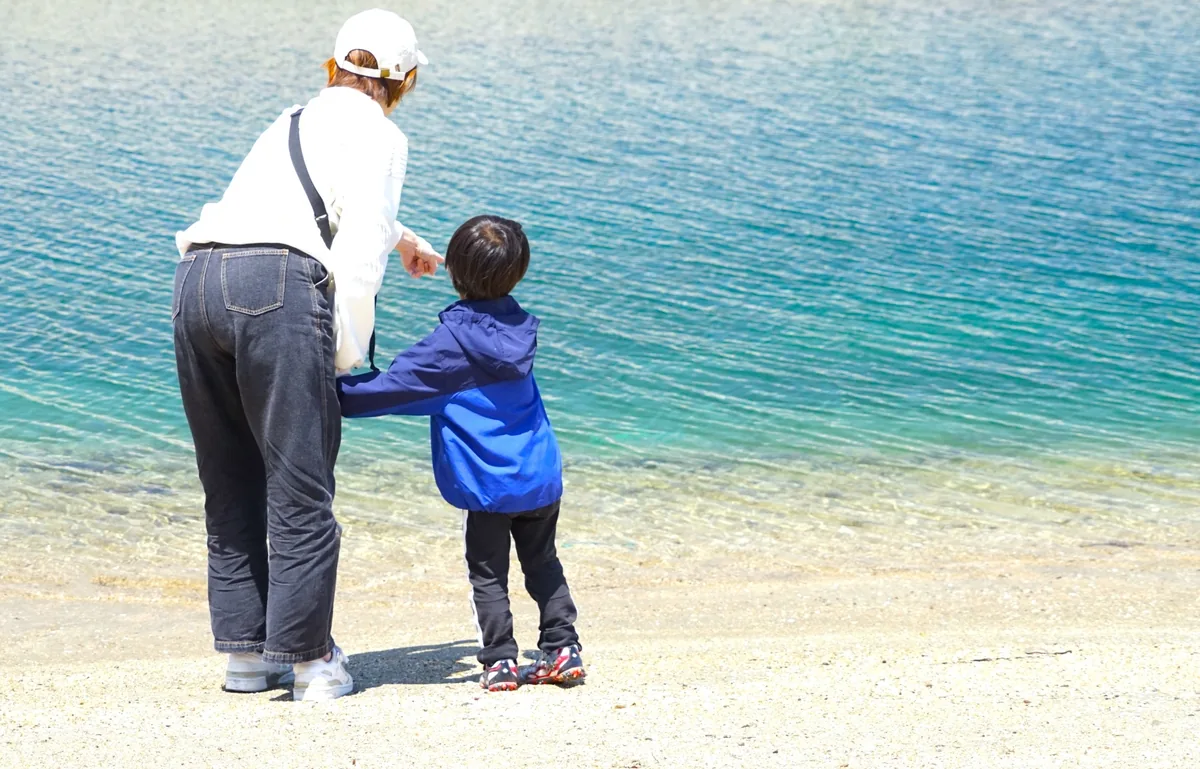 親子で波打ち際を歩くイメージ（阿字ヶ浦海水浴場の現地写真ではありません）