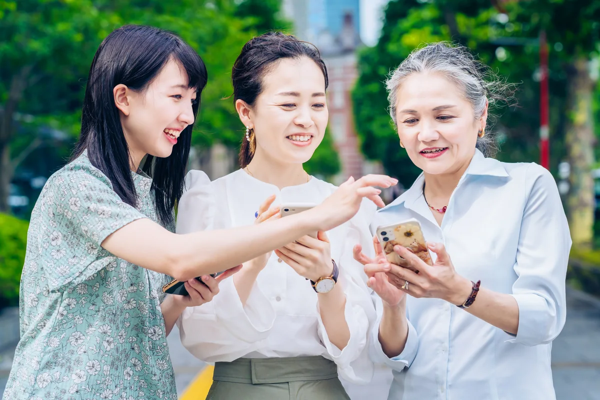 スマートフォンを見ながら手続きを確認する人たち
