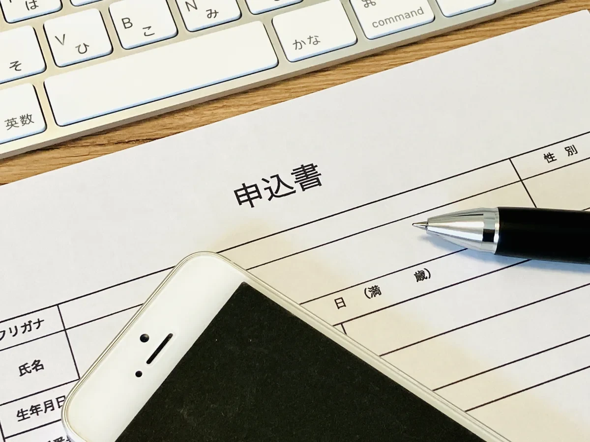 事前登録をイメージした申込書とスマートフォン
