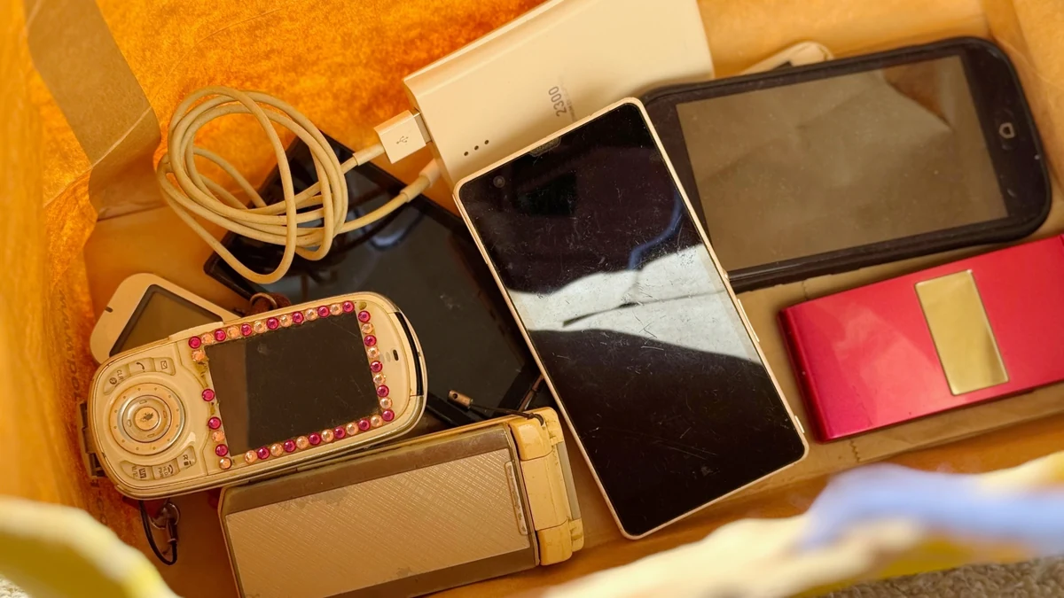 紙袋にまとめたスマートフォンや携帯電話などの小型電子機器